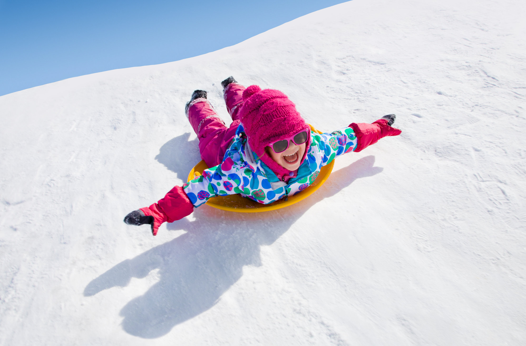 little girl riding on snow slides in winter time EDMS